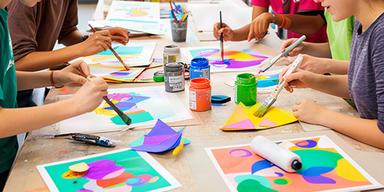 Jongeren werken aan kleurrijke posters tijdens een kunstworkshop in Spijkenisse