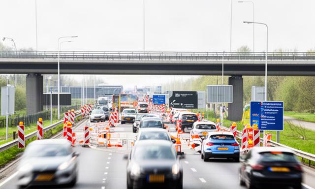 Verkeer op een toegangsweg naar Spijkenisse met tijdelijke wegafzetting